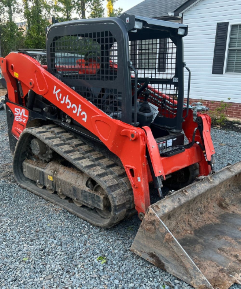 Orange skid steer with a bucket attachment being used for equipment rental Seymour TN.